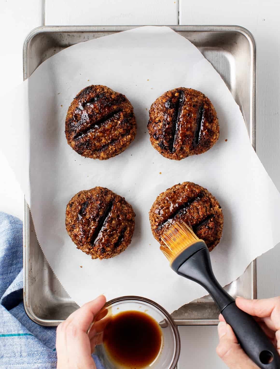 Brushing cooked patties with Worcestershire sauce
