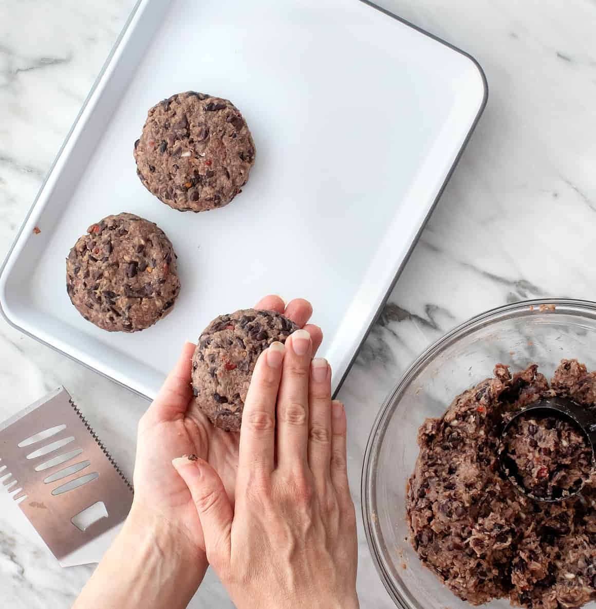 Hands forming black bean patties