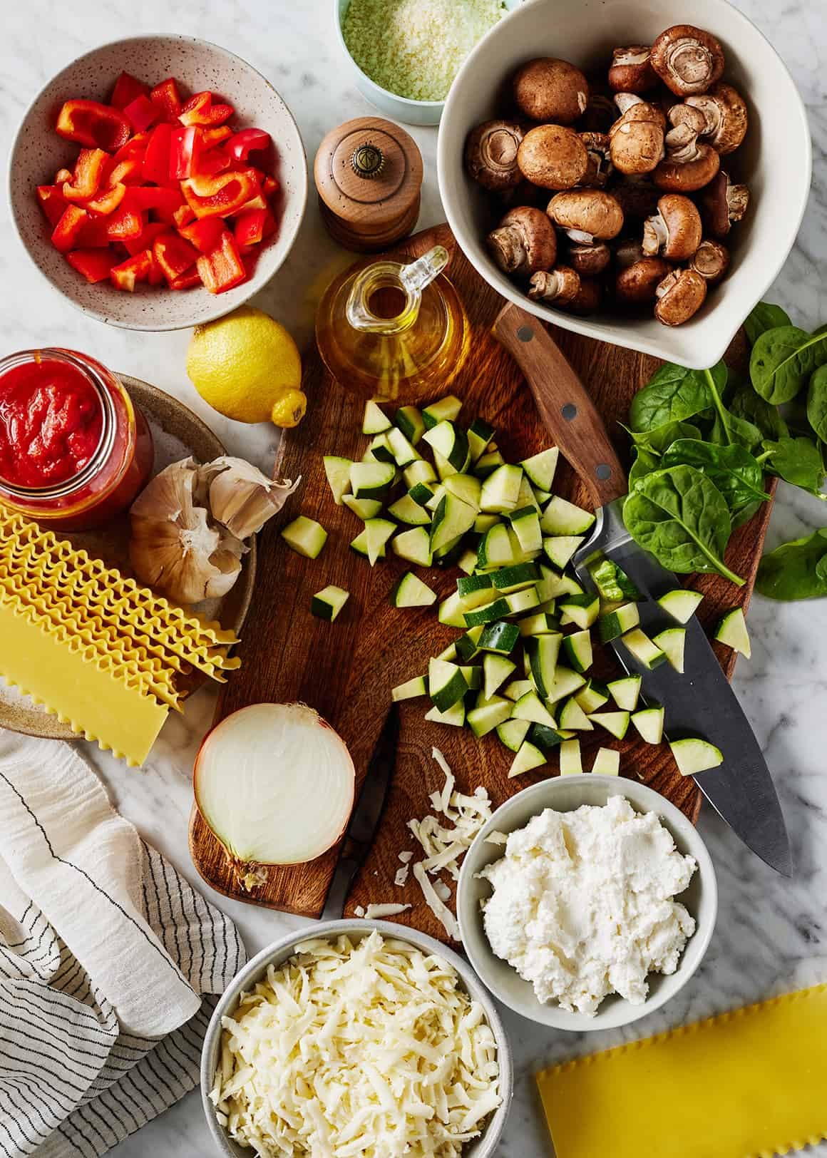 Recipe ingredients - fresh veggies, cheese, tomato sauce, and pasta