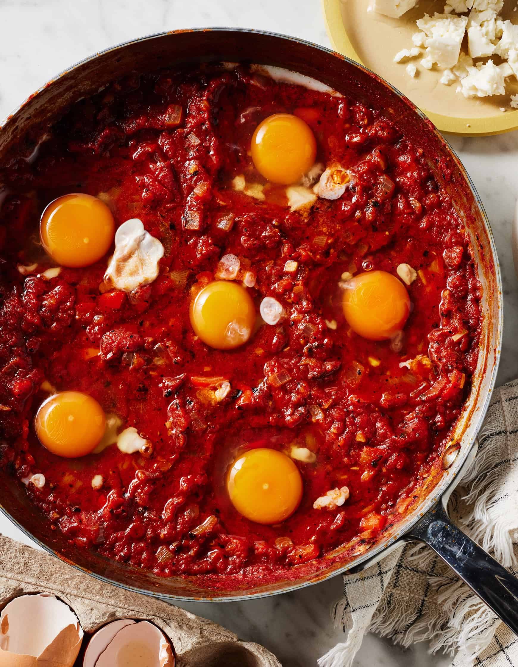 Eggs cooking in tomato and red pepper sauce