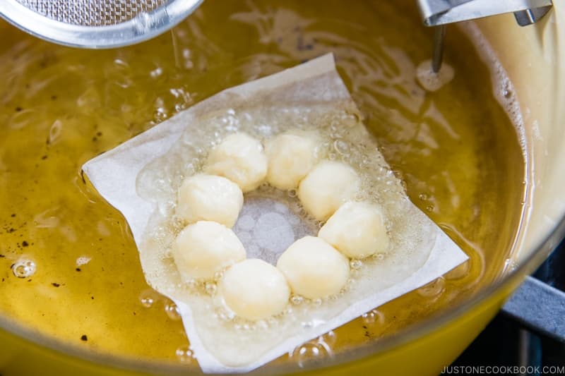 Let go of the donut and paper and set a timer for 1 minute 15 seconds for the first side. Tip: Only add enough donuts for a 5–10 degree drop in temperature. I only fry 2 donuts at a time. If the oil cools down too much, the donuts won’t fry properly.