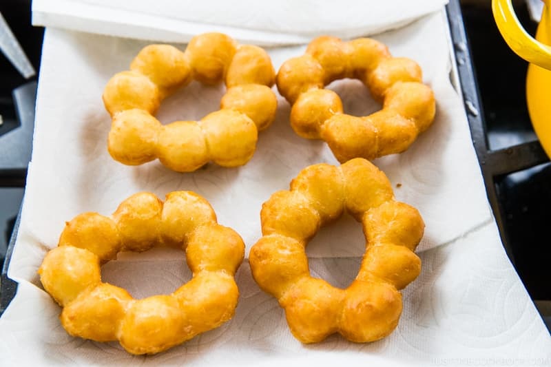 When the 45-second timer beeps, scoop up the donuts with the skimmer or tongs and drain the oil well. Then, transfer to the paper towel to drain any extra oil. Glaze the donuts while you continue frying the remaining donuts (see the next step).