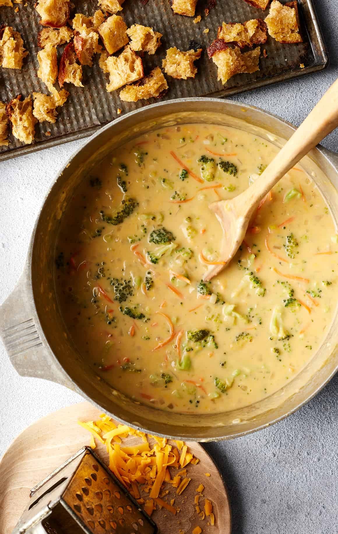 Pot of broccoli cheese soup with wooden spoon