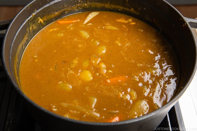 Simmer, uncovered, on medium-low heat, stirring frequently, until the curry becomes thick, about 5–10 minutes. If your curry is too thick, you can add water to thin the sauce. When you stir, make sure that no roux or food is stuck to the bottom of the pot; otherwise, it may burn.